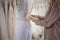 Hostess of the wedding salon looks at the wedding dress. Small business,