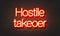 Hostile takeover neon sign on brick wall background.