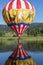 Hot Air Ballon dipping into a Mountain lake .