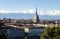 A hot-air ballon flying near the Mole, in a Turin panorama with the alps in background.