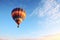 a hot air balloon ascending into a clear morning sky