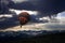 Hot Air Balloon Escaping over Mountain Peaks