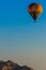 Hot air balloon floating above mountain