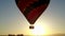 Hot air balloon flying in front of sun