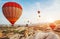 Hot air balloon flying over rock landscape at Turkey. Cappadocia