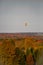 Hot air balloon flying over Wisconsin forest and farmland in late September