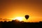 Hot air balloon flying at sunrise over Masai Mara