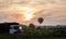 Hot Air Balloon and old dump truck in grass field at sunrise