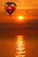 Hot air balloon over a golden lake sunset