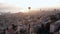 Hot air balloon over Haifa cityscape, port, and Haifa bay at sunrise.