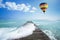 Hot air balloon over the ocean with pathway