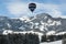 Hot air balloon over snowy alps