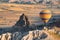 Hot air balloon with rainbow colors pattern rising over the Cappadocian valley