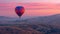 a hot air balloon ride at dawn, as it glides gracefully over a picturesque landscape of rolling hills and vineyards.