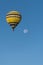 A hot air balloon sails a blue sky.