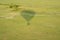 Hot air balloon shadow over the Masaai Mara Reserve, with antelope impala animals running in the grass. Aerial view, Kenya Africa