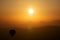 Hot air balloon silhouette with sun rising over the mountains