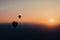 Hot air balloon silhouette with sun rising over the mountains