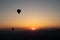 Hot air balloon silhouettes with sun rising over the mountains