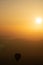 Hot air balloon silhouettes with sun rising over the mountains