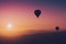 Hot air balloon silhouettes with sun rising over the mountains