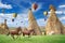 Hot air ballooning and two horses running in Cappadocia, Turkey.