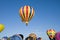 Hot-air balloons ascending over inflating ones