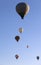 Hot air balloons on blue clear sunlit sky at early sunny morning