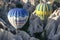 Hot air balloons float through the beautiful Cappadocia landscape near the town of Goreme in Turkey at sunrise.