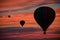 Hot-air balloons floating among clouds at dawn