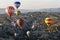 Hot air balloons fly over the beautiful landscape near Goreme in the Cappadocia region of Turkey.