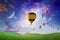 Hot air balloons fly in sunset sky against background of glowing