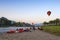 Hot air balloons flying over Nam Song River and tourist kayaks in Vang Vieng, popular resort town in Lao PDR