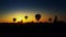 Hot air balloons landing in field over amazing sunset. Dramatic color grading