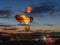 Hot air balloons lit up in formation during the early morning sky.