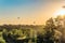 Hot air balloons over the roofs of suburban houses in the light of the low evening sun backlight