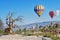 Hot air balloons over rural landscape, in Cappadocia, Turkey