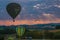 Hot air balloons and paragliding flying at sunrise in Umbria