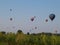 Hot air balloons racing across horizon