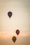 Hot air balloons rising on the horizon at sunset at an airshow