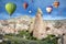 Hot air balloons in the sky over the cave town, Pink Valley, Cappadocia, Turkey