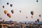 Hot air balloons at sunrise flying over Cappadocia, Turkey. A balloon with a flag of Turkey