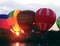 Hot air baloons flying in the evening sky near the lake