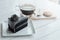 Hot americano black coffee and A piece of charcoal cake on white wooden table.