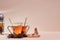 Hot aromatic tea on pink background. Glass teapot. Stack of brown sugar and infusion. Copy space. Tea ceremony concept