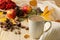 Hot autumn drink, coffee or cocoa, with yellow leaves and decorative pumpkins, acorns and apples on a natural wooden table. autumn