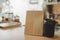 Hot black coffee cup and dessert paper bag waiting for customer on counter in modern cafe coffee shop