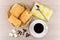 Hot black coffee, wicker basket with flaky biscuits, sugar cubes