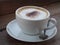 Hot cappuccino with full fine bubble cream little cacao powder served in white ceramic coffee cup
