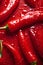 Hot chili peppers depicted in contrast against a dark background. The juicy, red peppers create a visual effect.